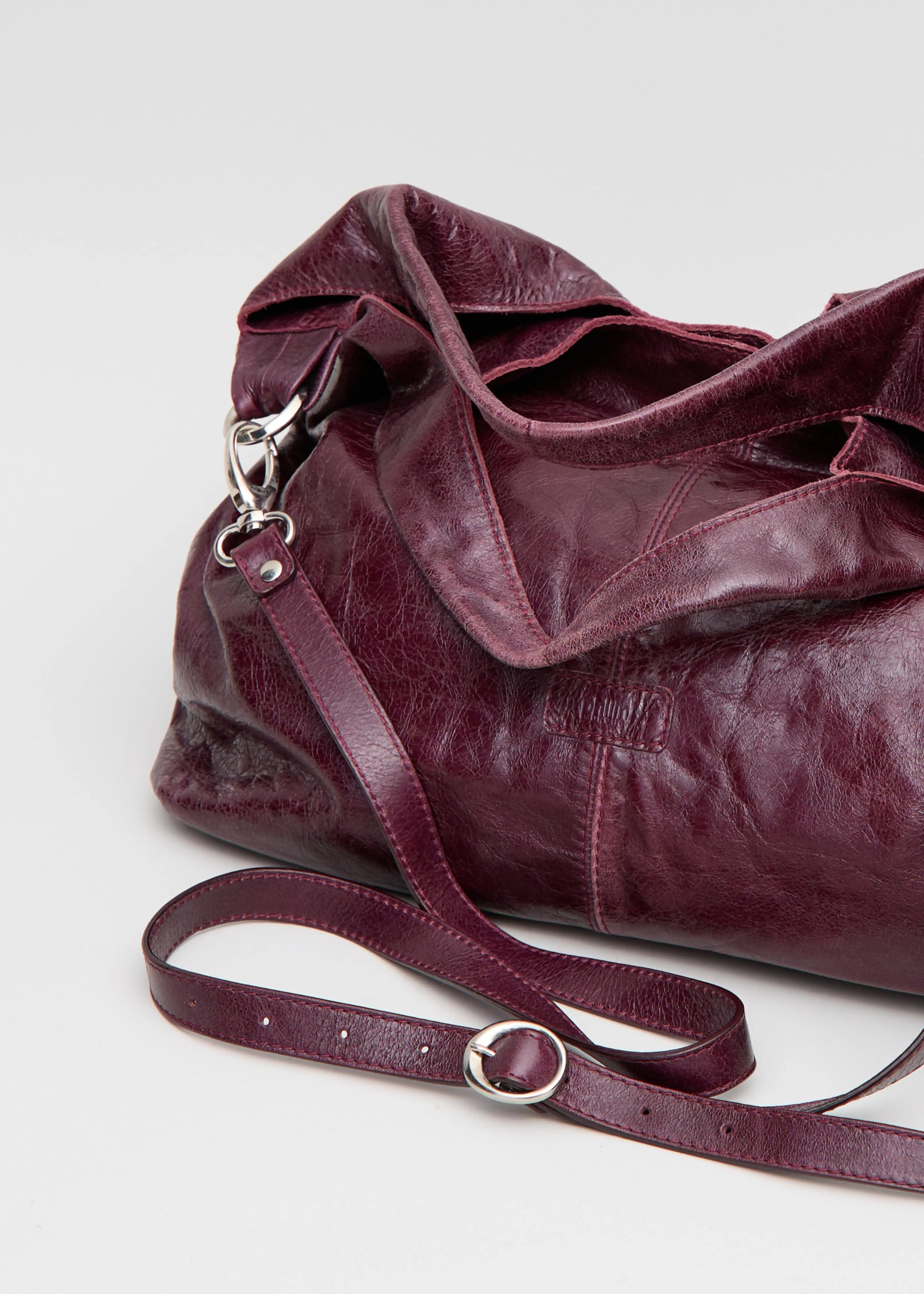 Close-Up view of the Philini Melanie Hobo Bag in burgundy calf leather, featuring two top handles and extended handle.  Premium minimalist shoulder bag for women