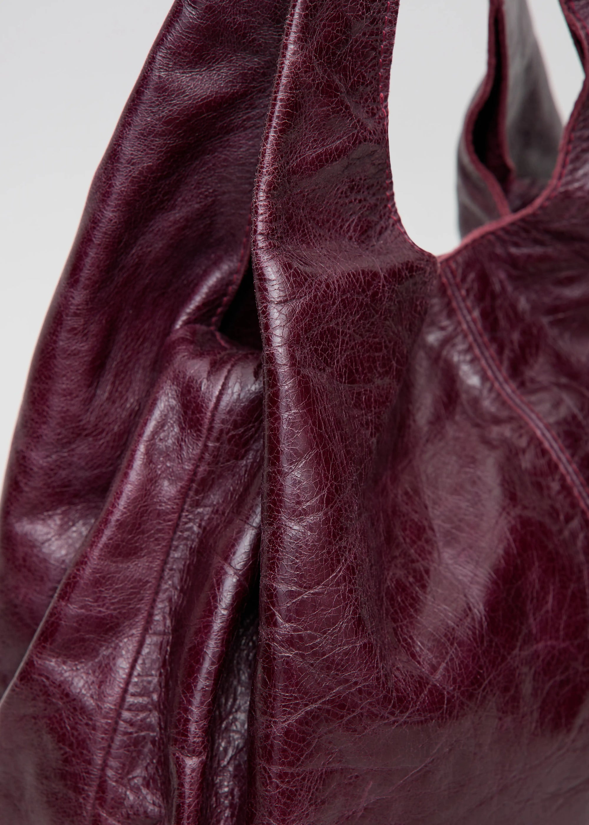 Close-Up view of the Philini Melanie Hobo Bag in burgundy calf leather, featuring two top handles.  Premium minimalist shoulder bag for women