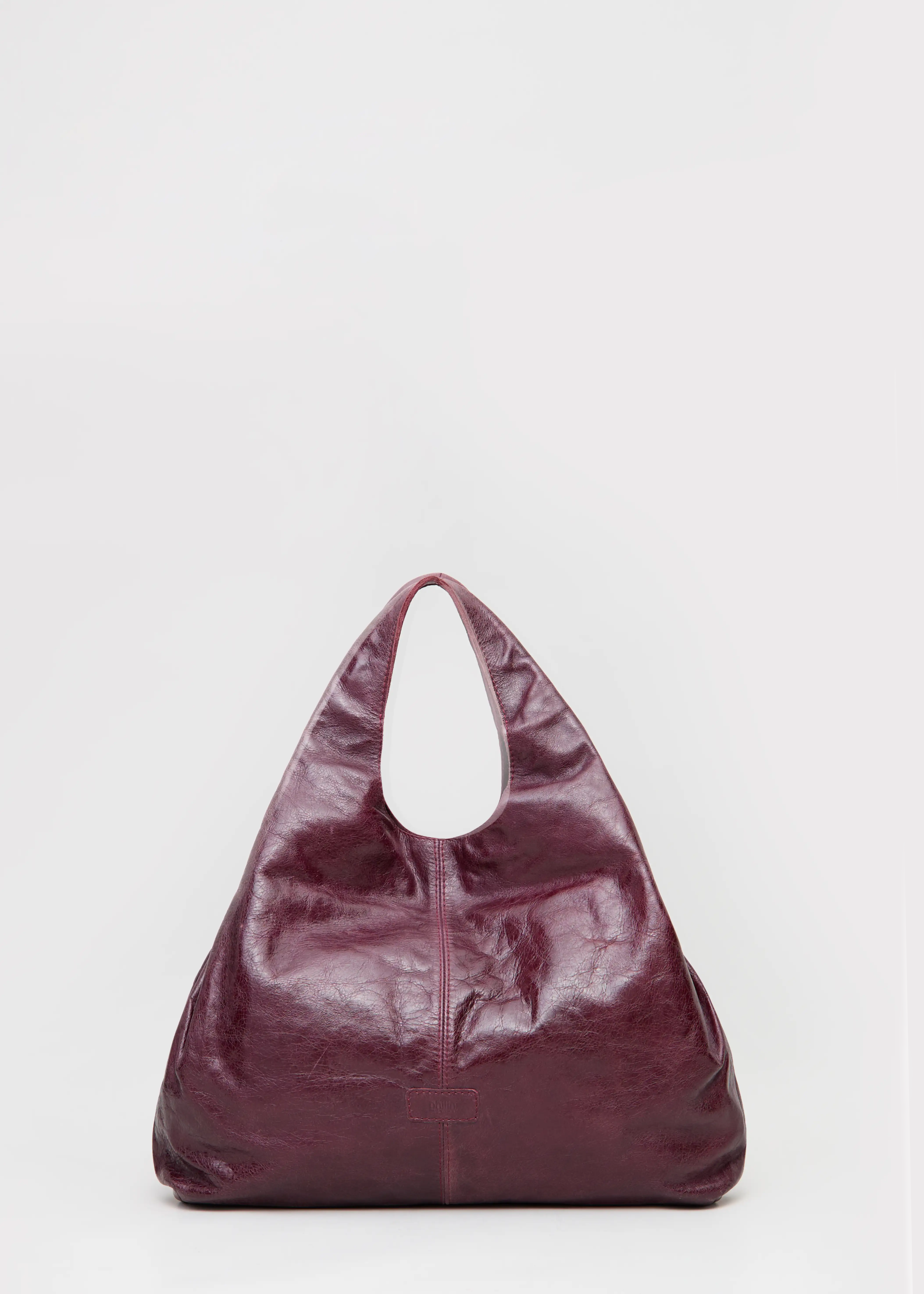Front view of the Philini Melanie Hobo Bag in burgundy calf leather, featuring two top handles and a leather patch with stamped logo. Elegant leather hobo tote