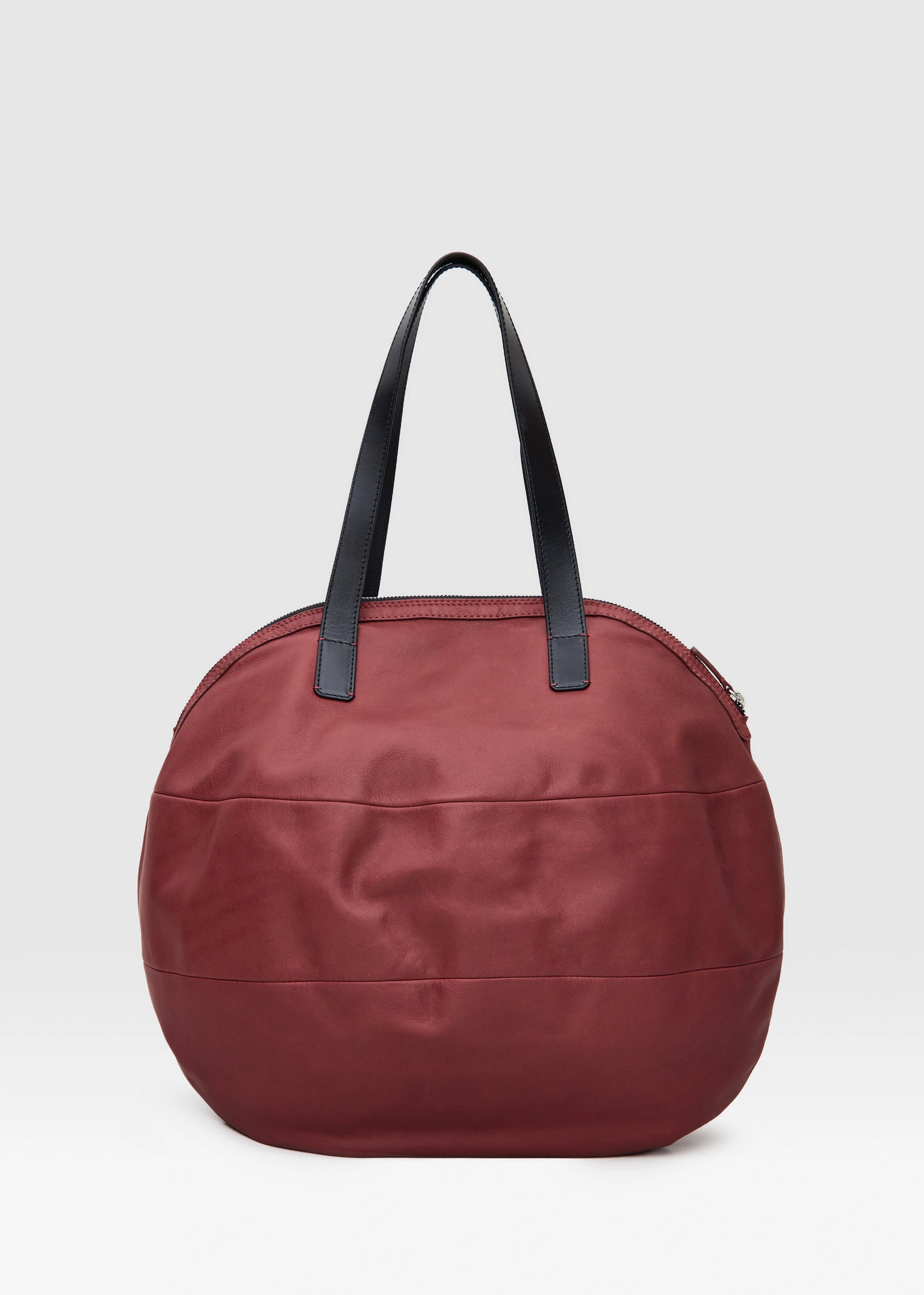 Back view of the Philini Nataly Handbag in bordeaux aniline calf leather, round silhouette with two black handles. Designer handbag in unique red made in Europe 