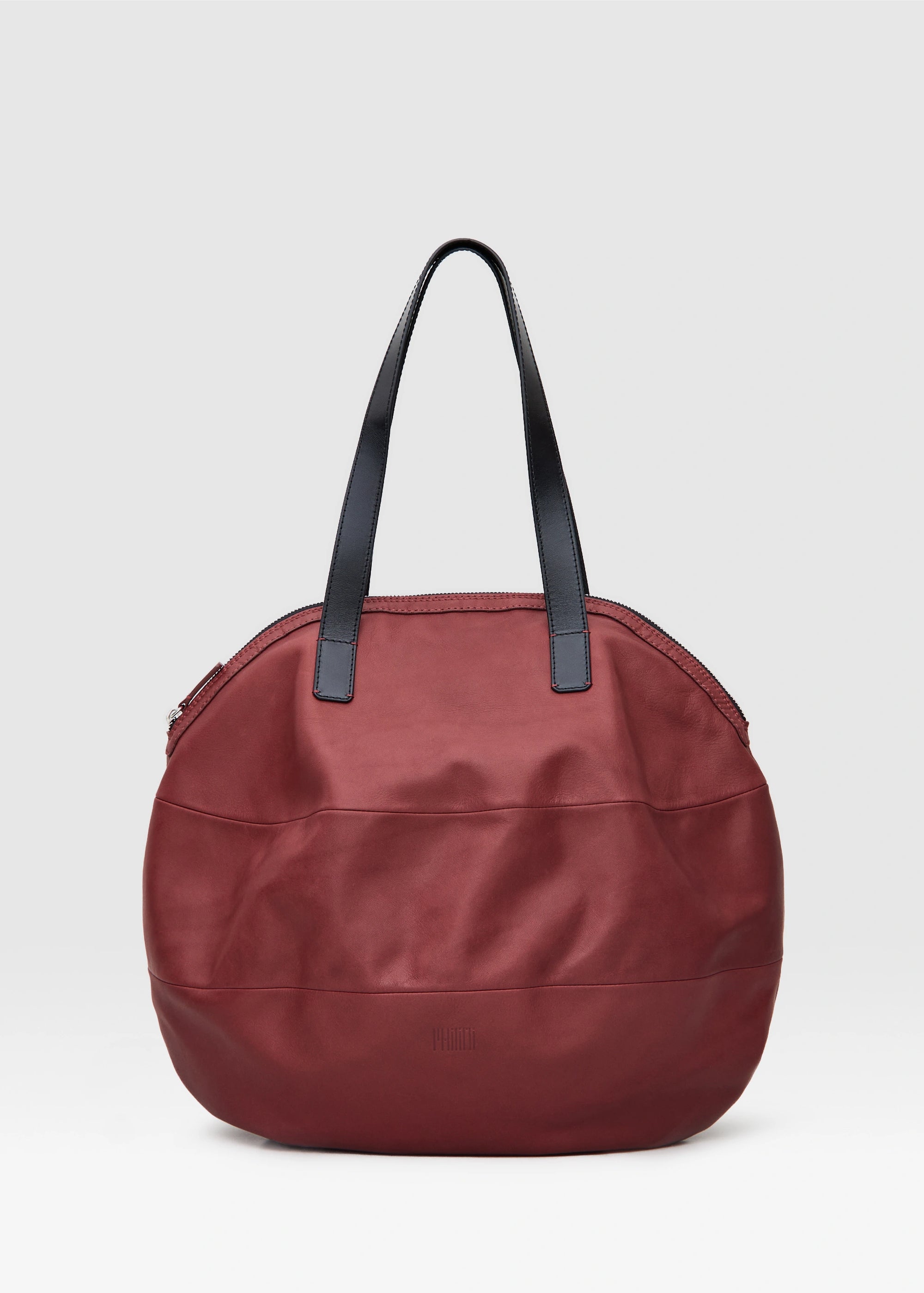 Front view of the Philini Nataly Handbag in bordeaux aniline calf leather, featuring a round silhouette with two black handles. A spacious leather bag, sustainably handcrafted,  spacious everyday handbag.
