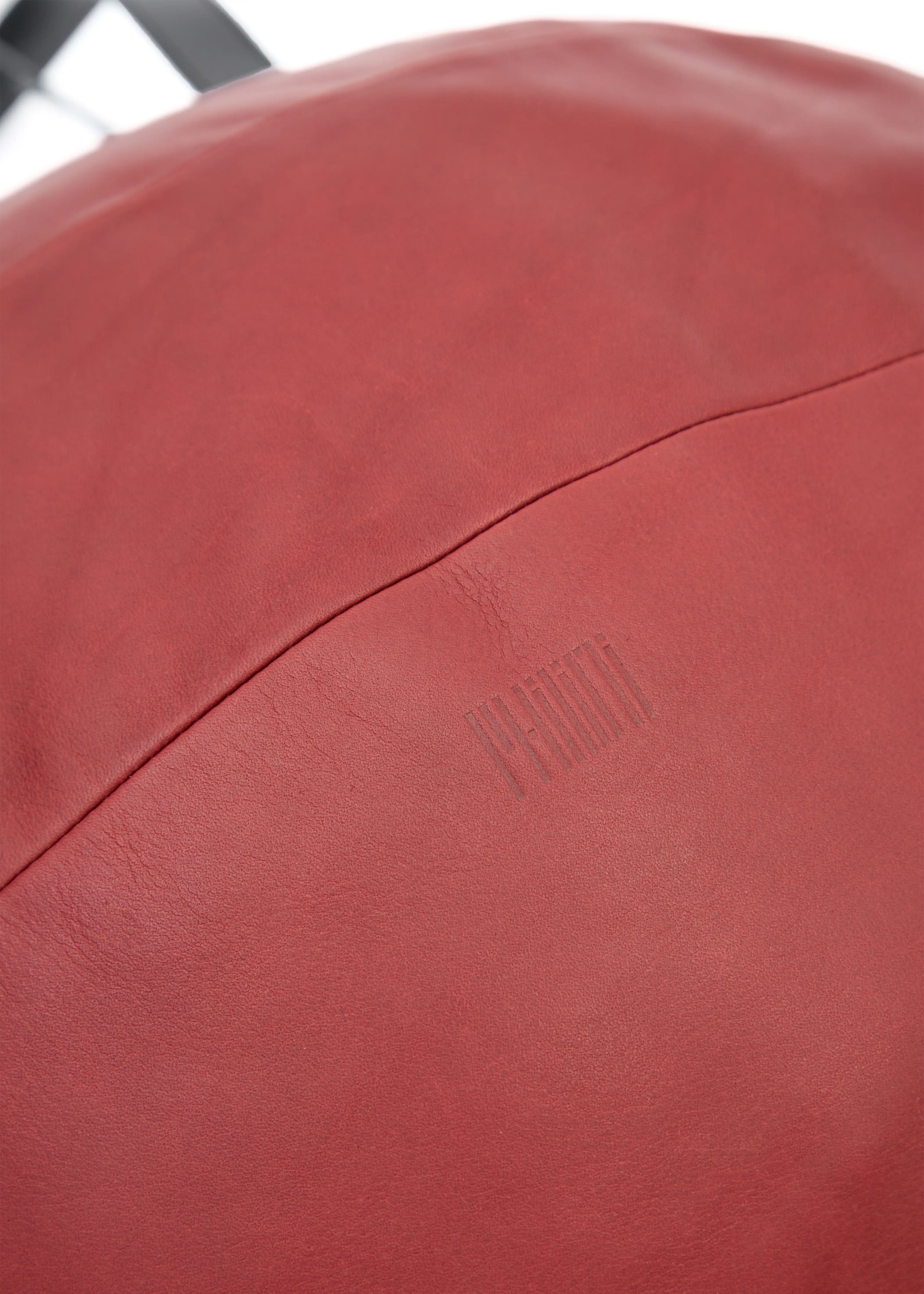 Close-up of the Philini Nataly Handbag in bordeaux aniline calf leather, round silhouette with stamped logo and premium leather texture. Luxury red leather shoulder bag a designer accessory
