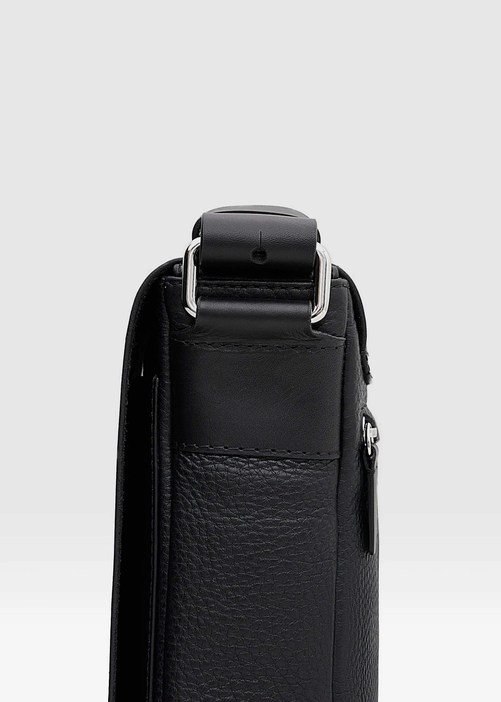Close-up side view of the Philini Olga Black Leather Messenger Bag, highlighting silver-colored handle details and the rich texture of premium full-grain leather.