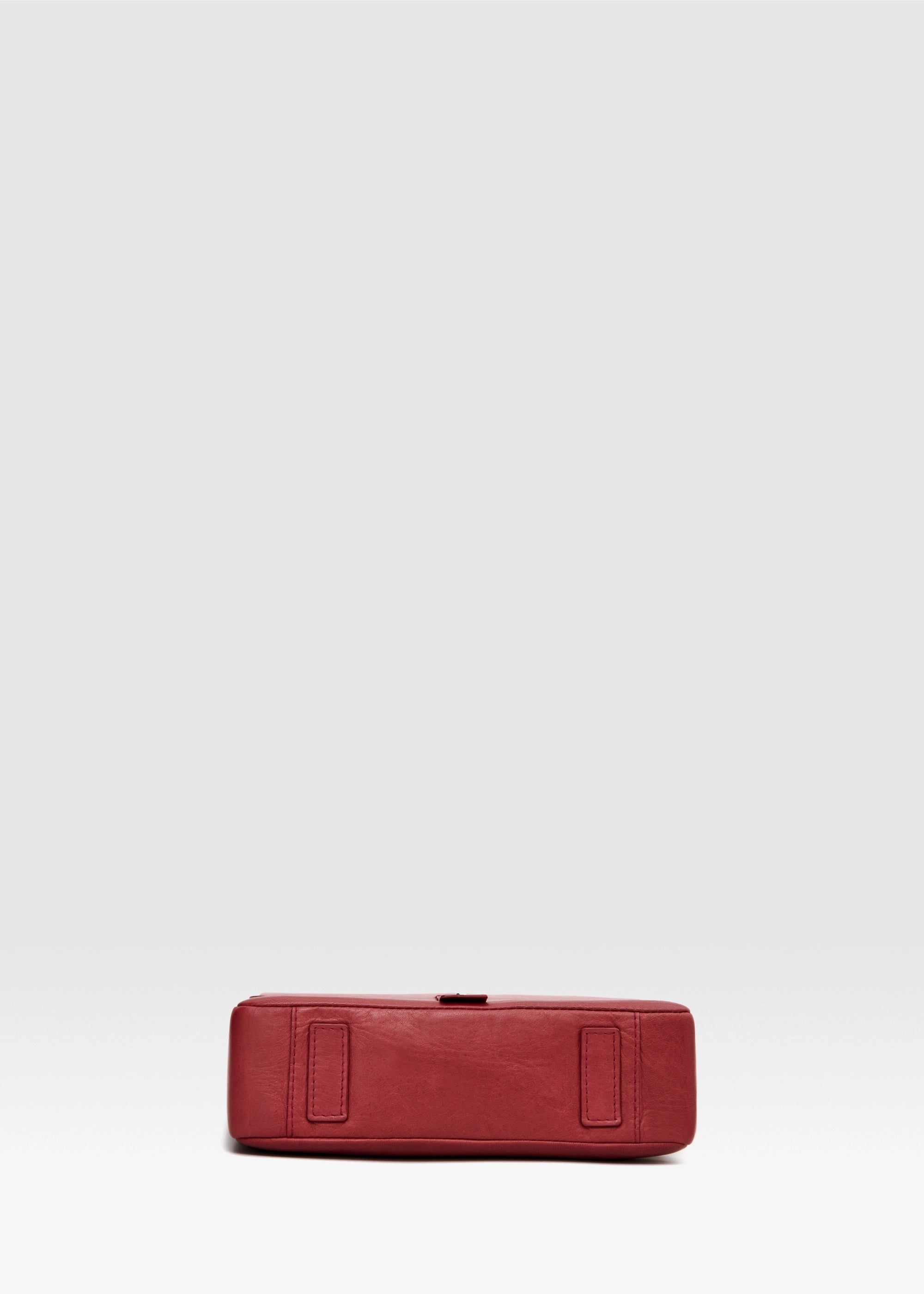 Bottom view of red aniline nappa leather Philini Olga postman-style Bag with rectangular base and leather feet. Handcrafted red leather handbag, structured and elegant