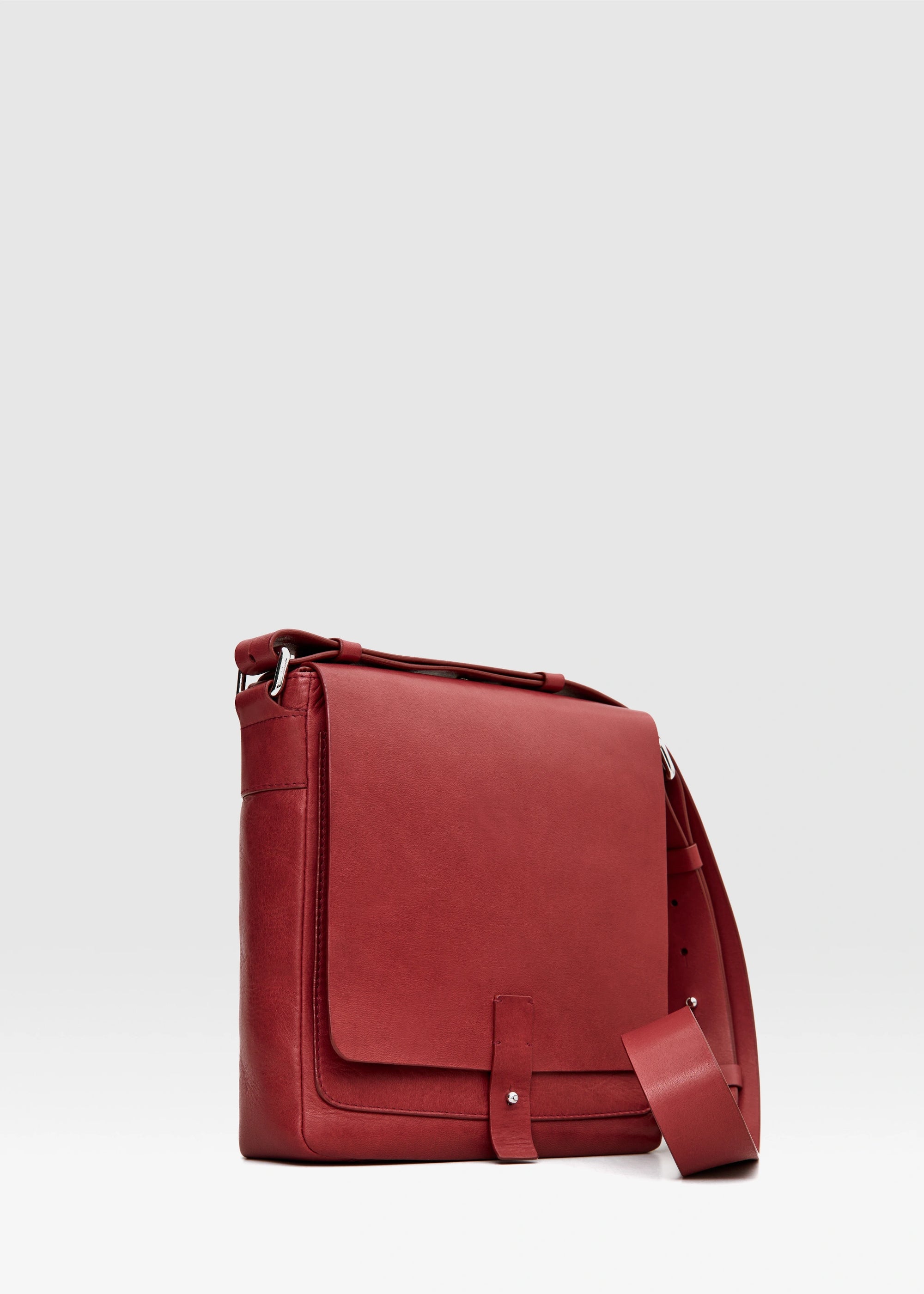 Side view of red aniline nappa leather Philini Olga Postman-style Bag with structured rectangular shape, silver cufflink closure, and adjustable strap. Premium handcrafted red leather purse for everyday style