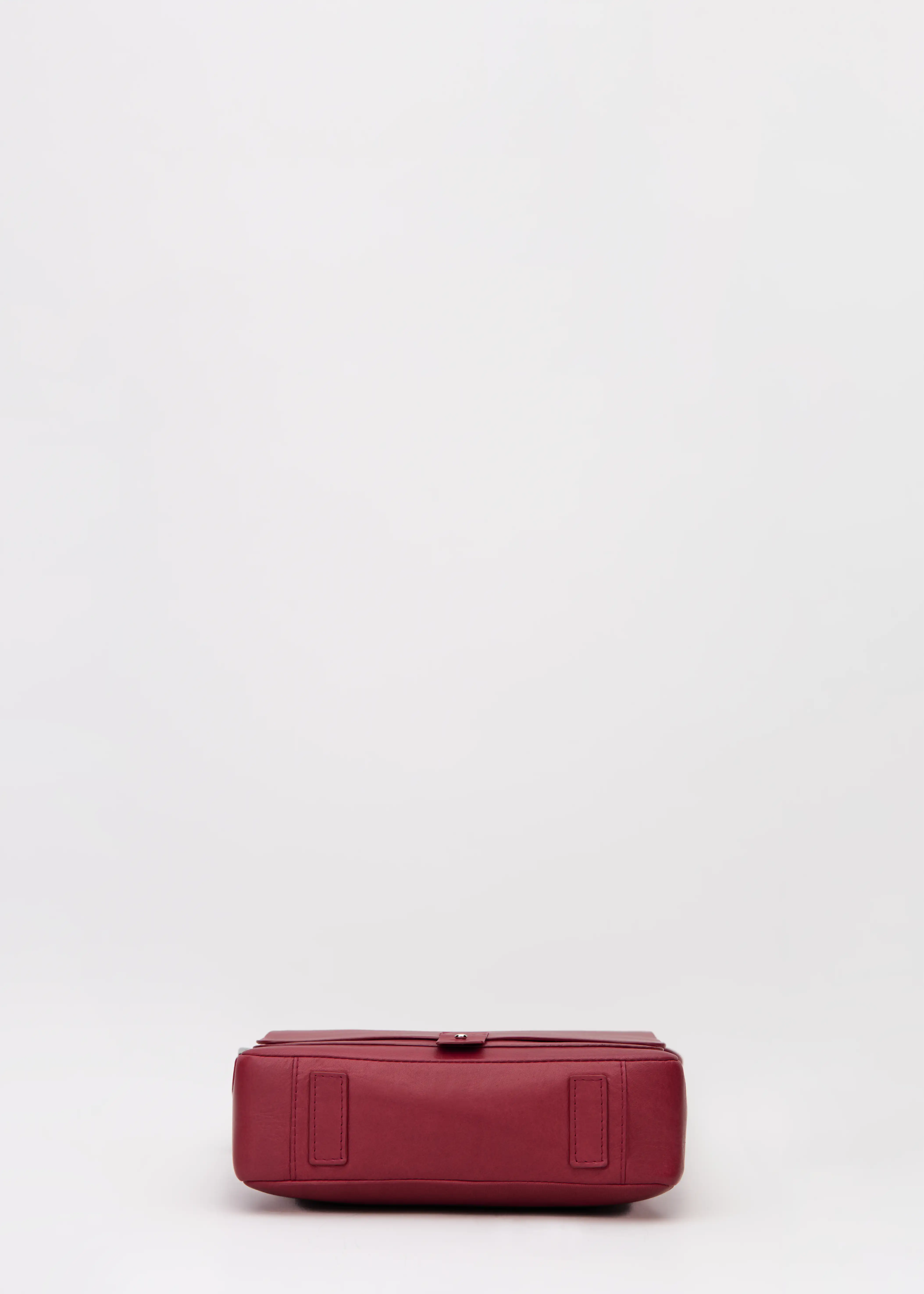 Bottom view of red aniline nappa leather Philini Olga postman-style Bag with rectangular base and leather feet. Handcrafted red leather handbag, structured and elegant