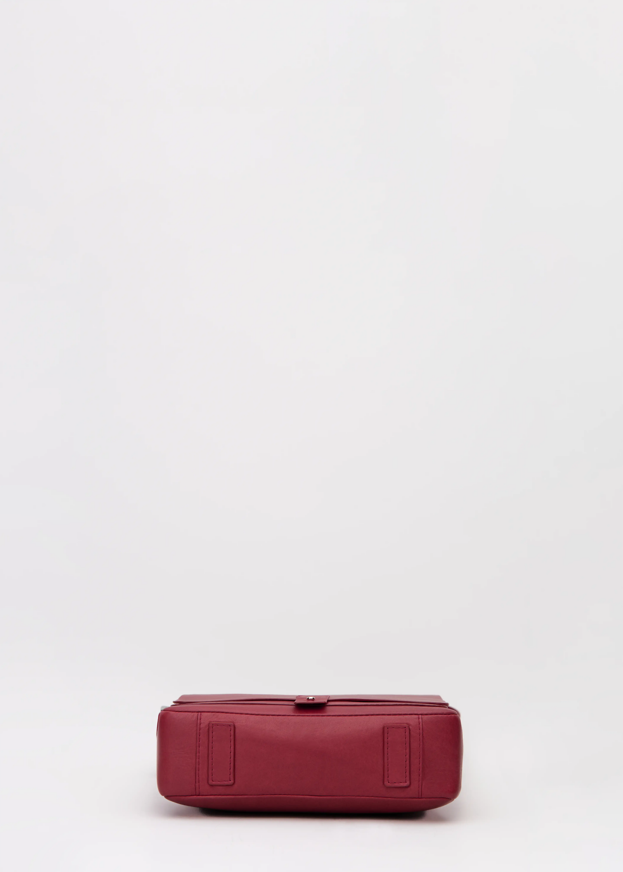 Bottom view of red aniline nappa leather Philini Olga postman-style Bag with rectangular base and leather feet. Handcrafted red leather handbag, structured and elegant