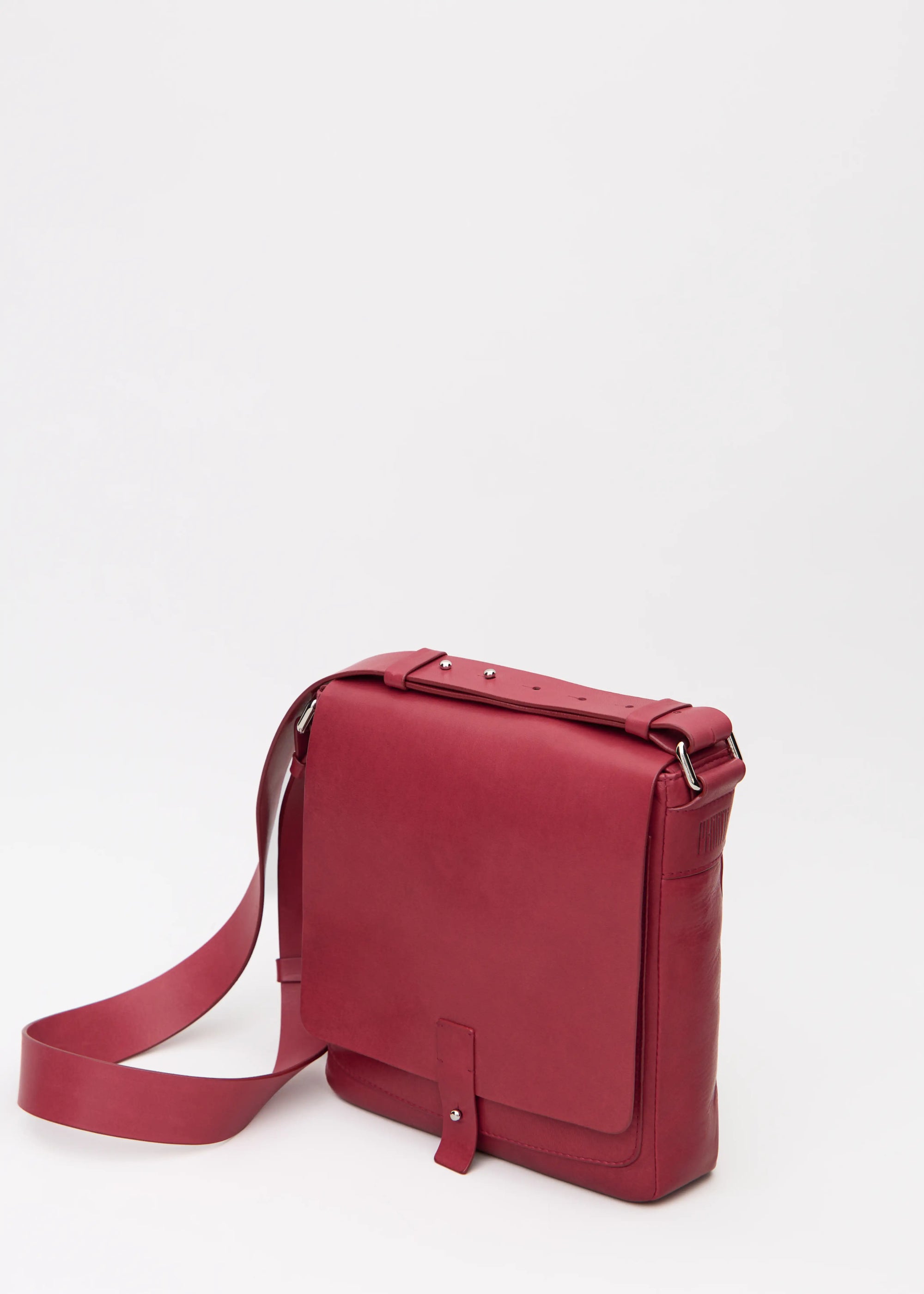 Side view of red aniline nappa leather Philini Olga Postman-style Bag with structured rectangular shape, silver cufflink closure, and adjustable strap. Premium handcrafted red leather purse for everyday style