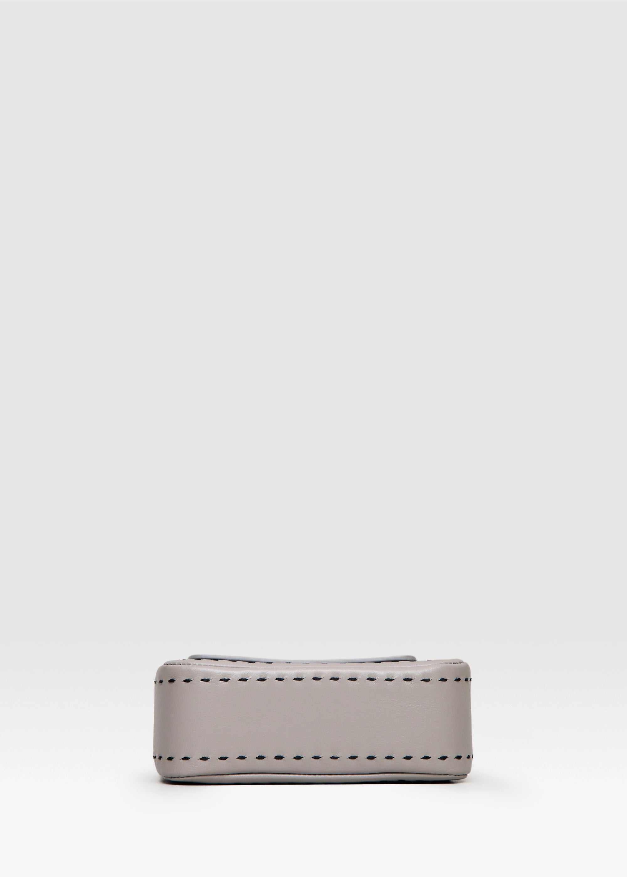 Bottom view of the Philini Saphira Purse in taupe aniline leather, compact rectangular shape with hand-stitched details, sleek half-lap flap, and convertible chain and leather straps. Elegant handmade leather evening purse.