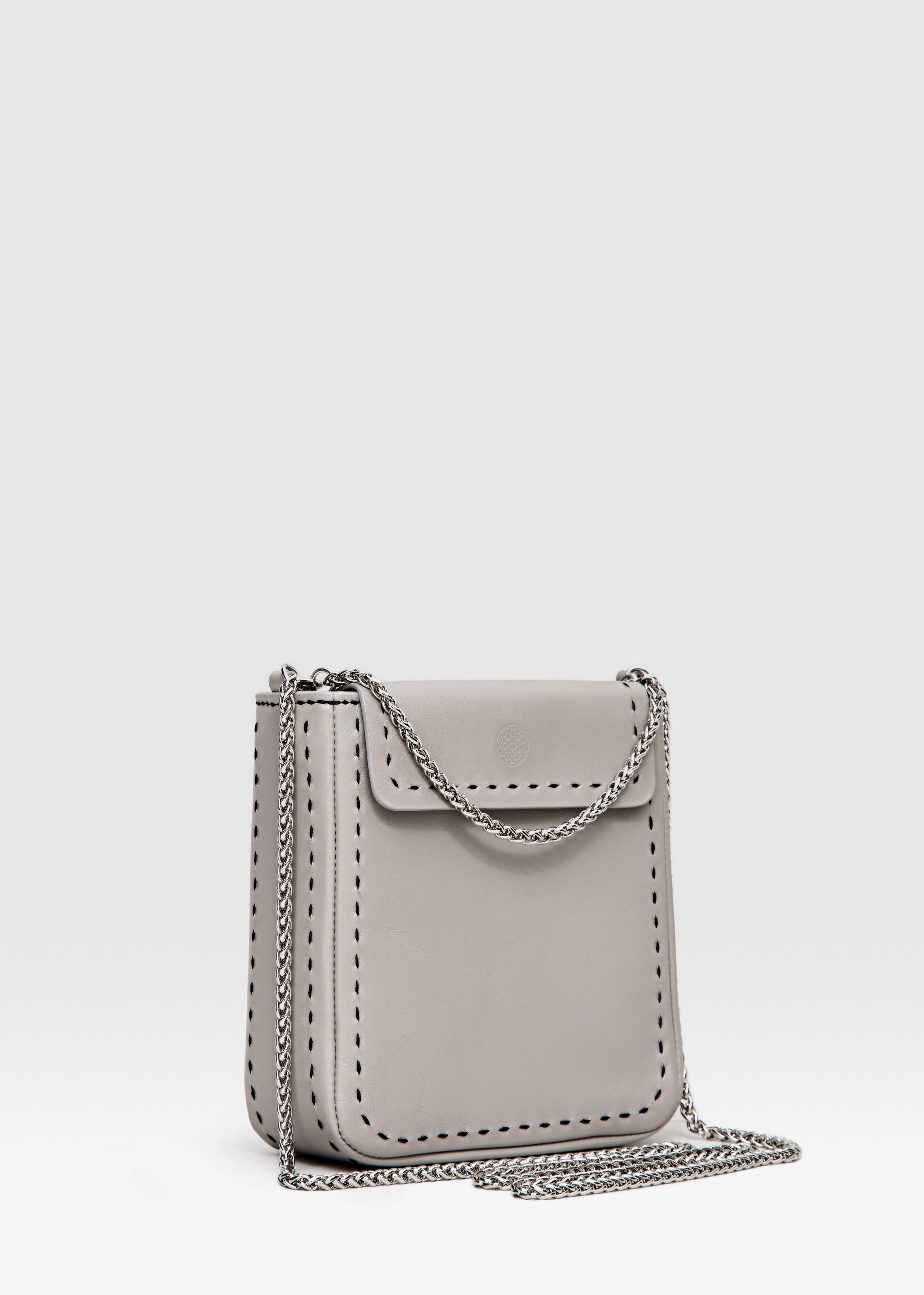 Side view of the Philini Saphira Purse in taupe aniline leather, compact rectangular shape with hand-stitched details, sleek half-lap flap, and convertible chain and leather straps. Elegant handmade leather evening purse.