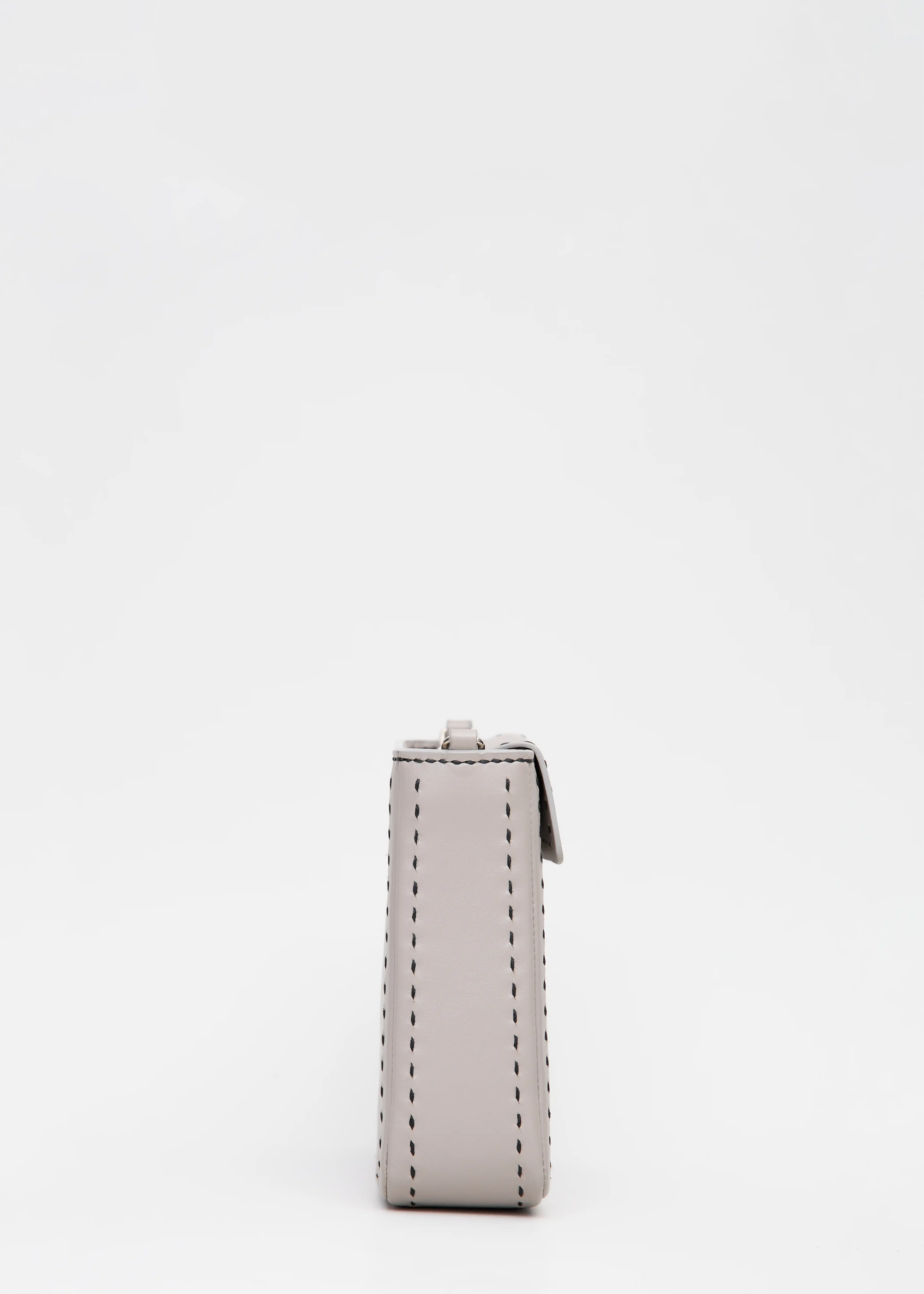 Side view of the Philini Saphira Purse in taupe aniline leather, compact rectangular shape with hand-stitched details, sleek half-lap flap, and convertible chain and leather straps. Elegant handmade leather evening purse.