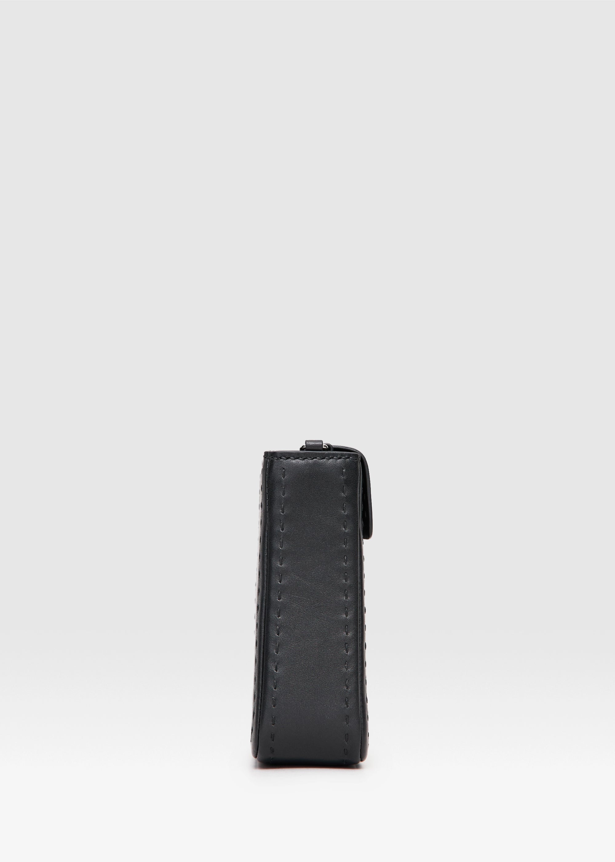 Profile view of the Philini Saphira Purse in black aniline leather, compact rectangular silhouette with hand-stitched accents, smooth half-lap flap, and versatile leather and chain handles. Handmade black leather evening bag.