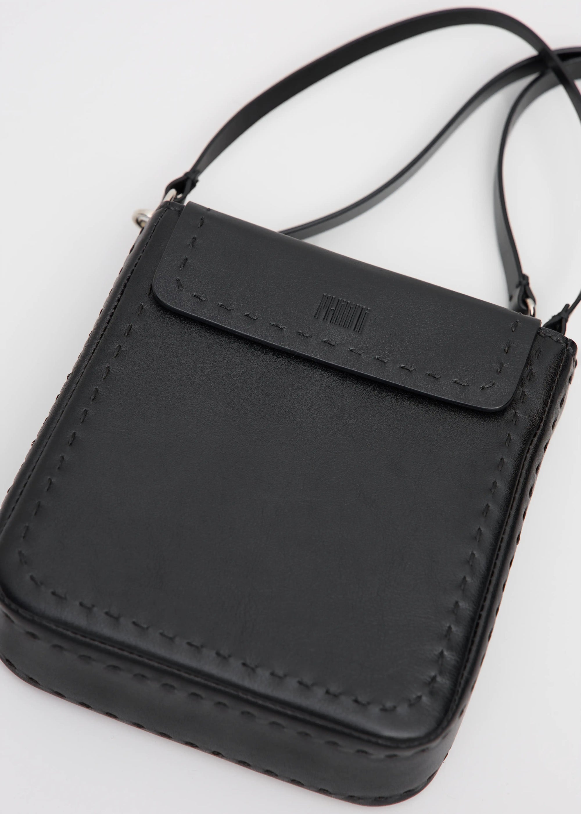 Close detailed view of the Philini Saphira Purse in black aniline leather, compact rectangular silhouette with hand-stitched accents, smooth half-lap flap, and versatile leather and chain handles. Handmade black leather evening bag.