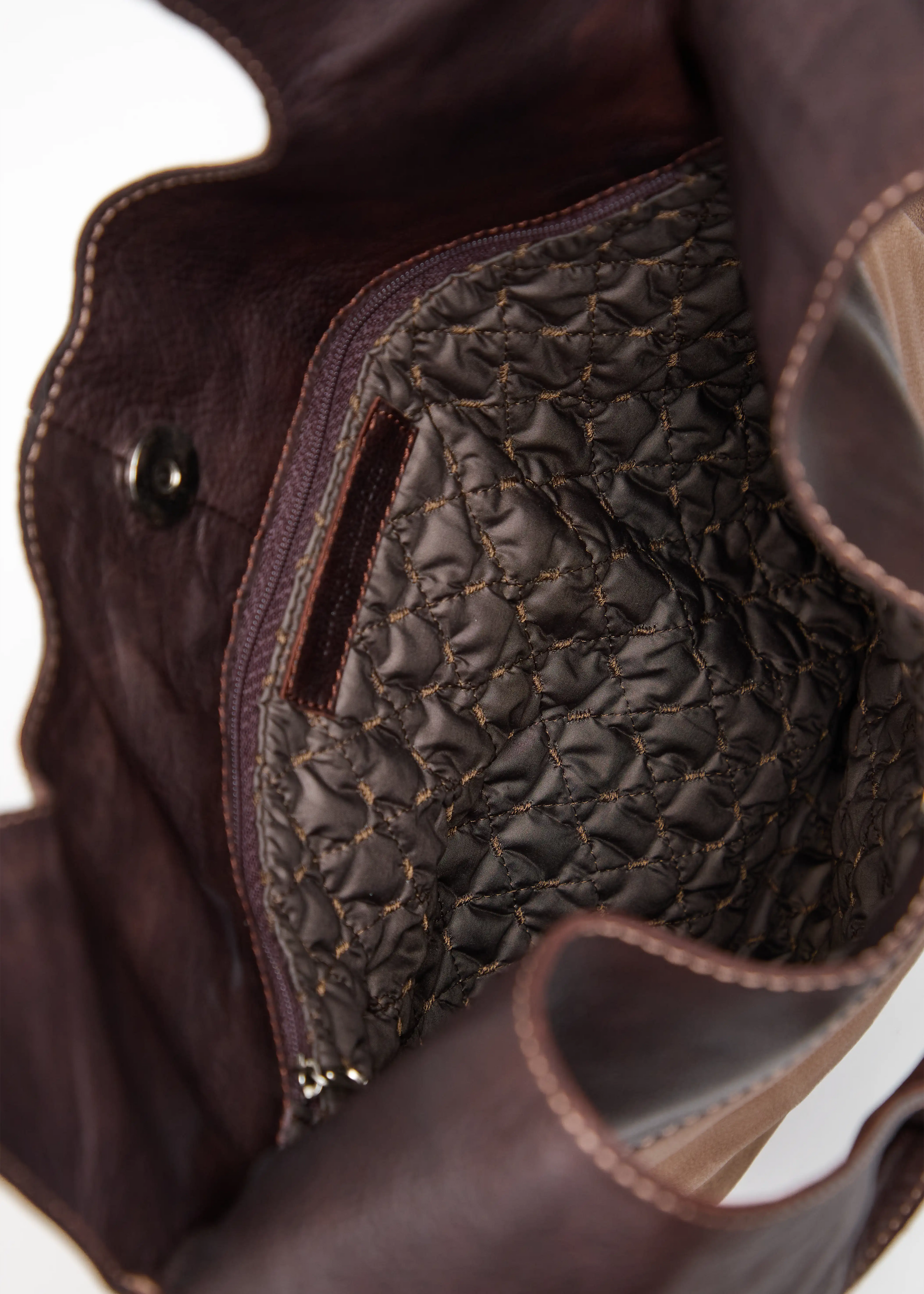 Inside view of the Philini Semfira Hobo Bag in brown nubuck and calf leather, revealing stitched brown lining, dual zip compartments, and magnetic snap closure. Premium spacious handcrafted leather tote bag for daily use