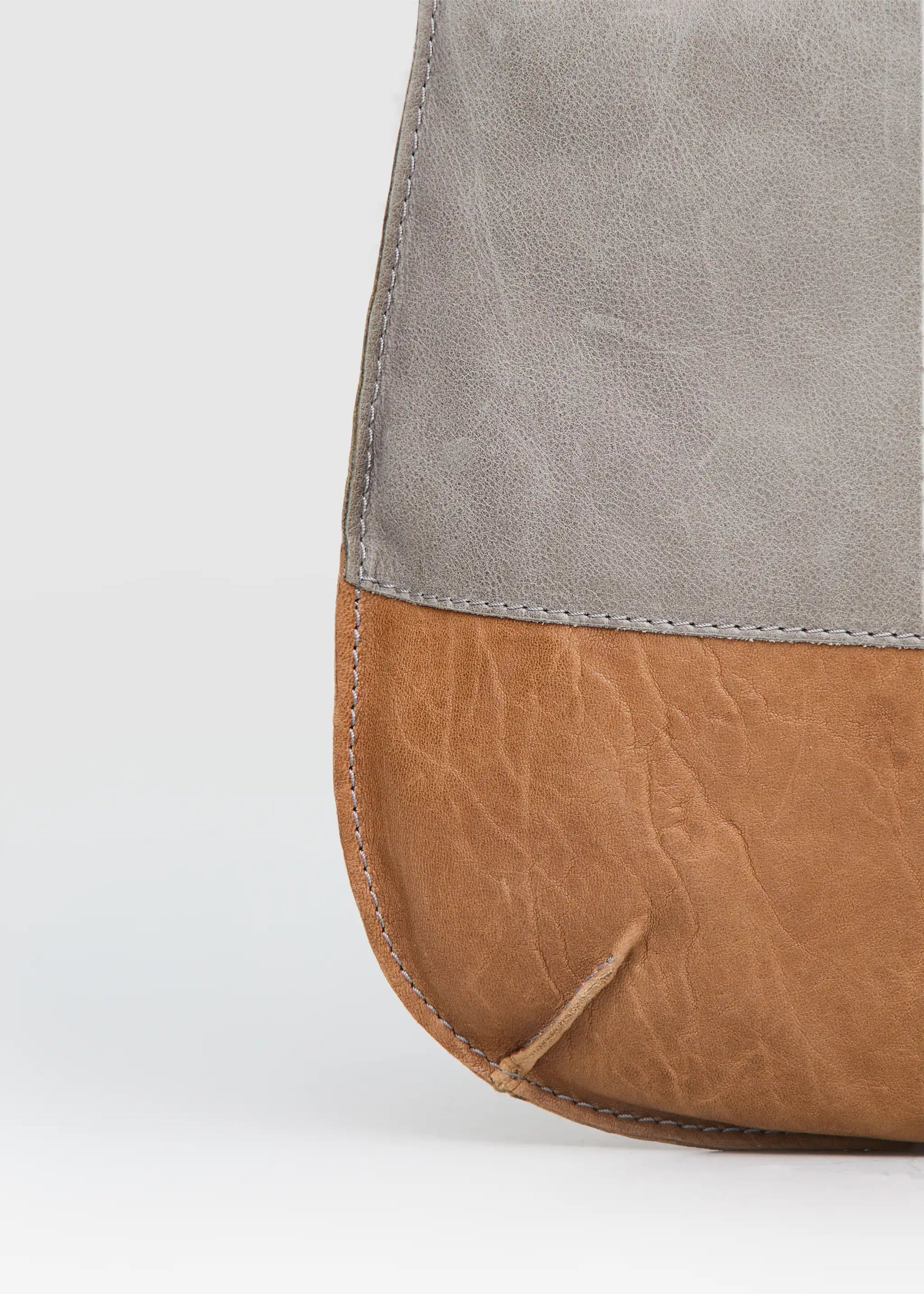 Close-up view of the Philini Semfira Hobo Bag in cognac wild calf leather, highlighting multicolor gentle straps and hand-maded stitching. Sustainable designer leather hobo