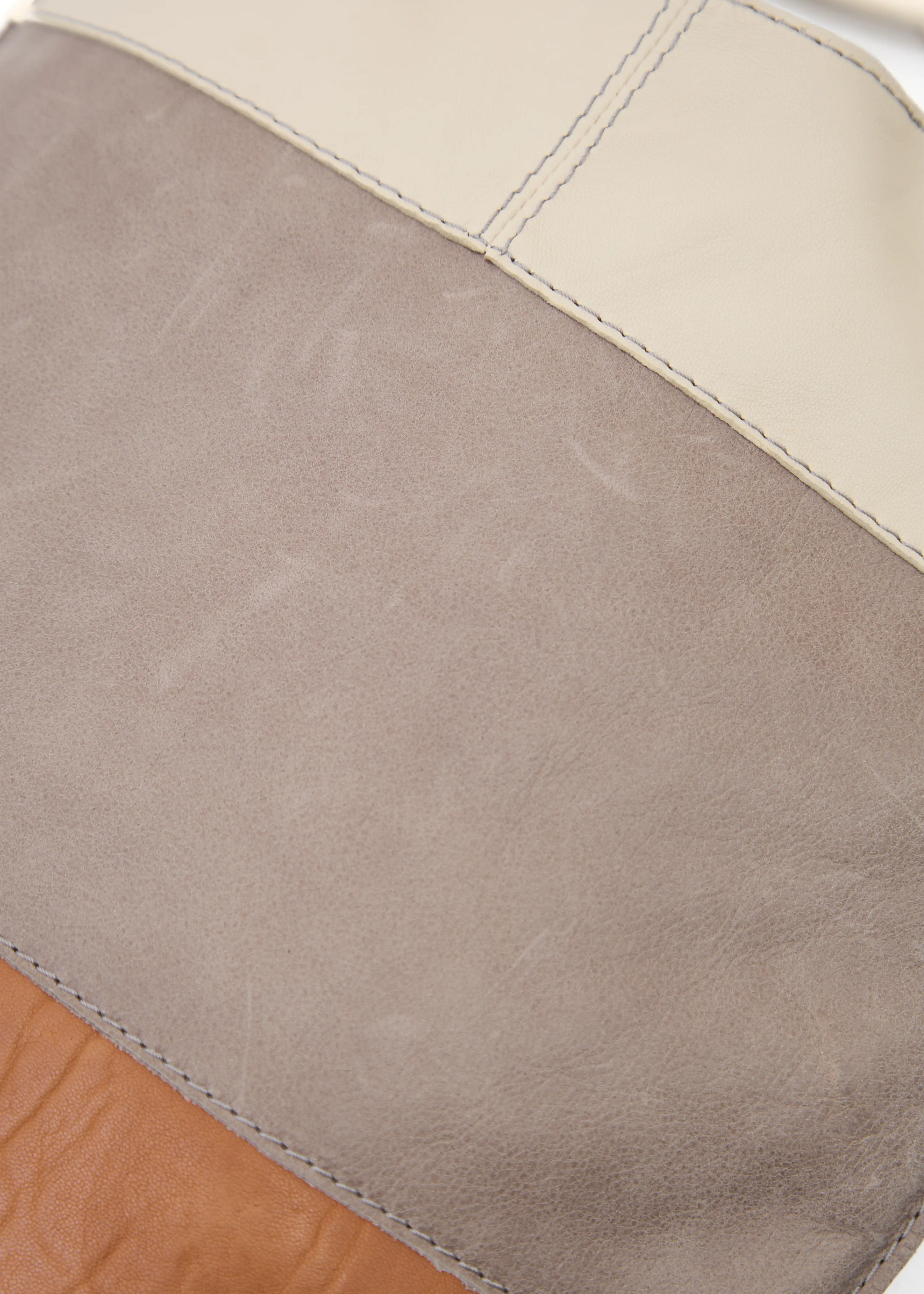 Close-up of the Philini Semfira Hobo Bag in cognac wild calf leather, highlighting multicolor gentle straps and hand-maded stitching. Sustainable designer leather hobo