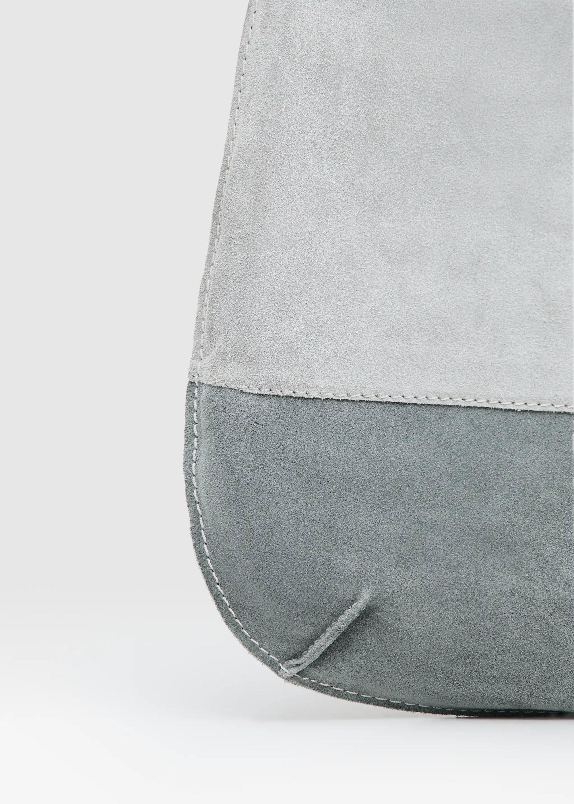 Close-Up Front view of the Philini Semfira Hobo Bag in grey suede, featuring pastel-colored leather straps, integrated handles, stamped logo and soft suede texture. Chic women’s suede hobo