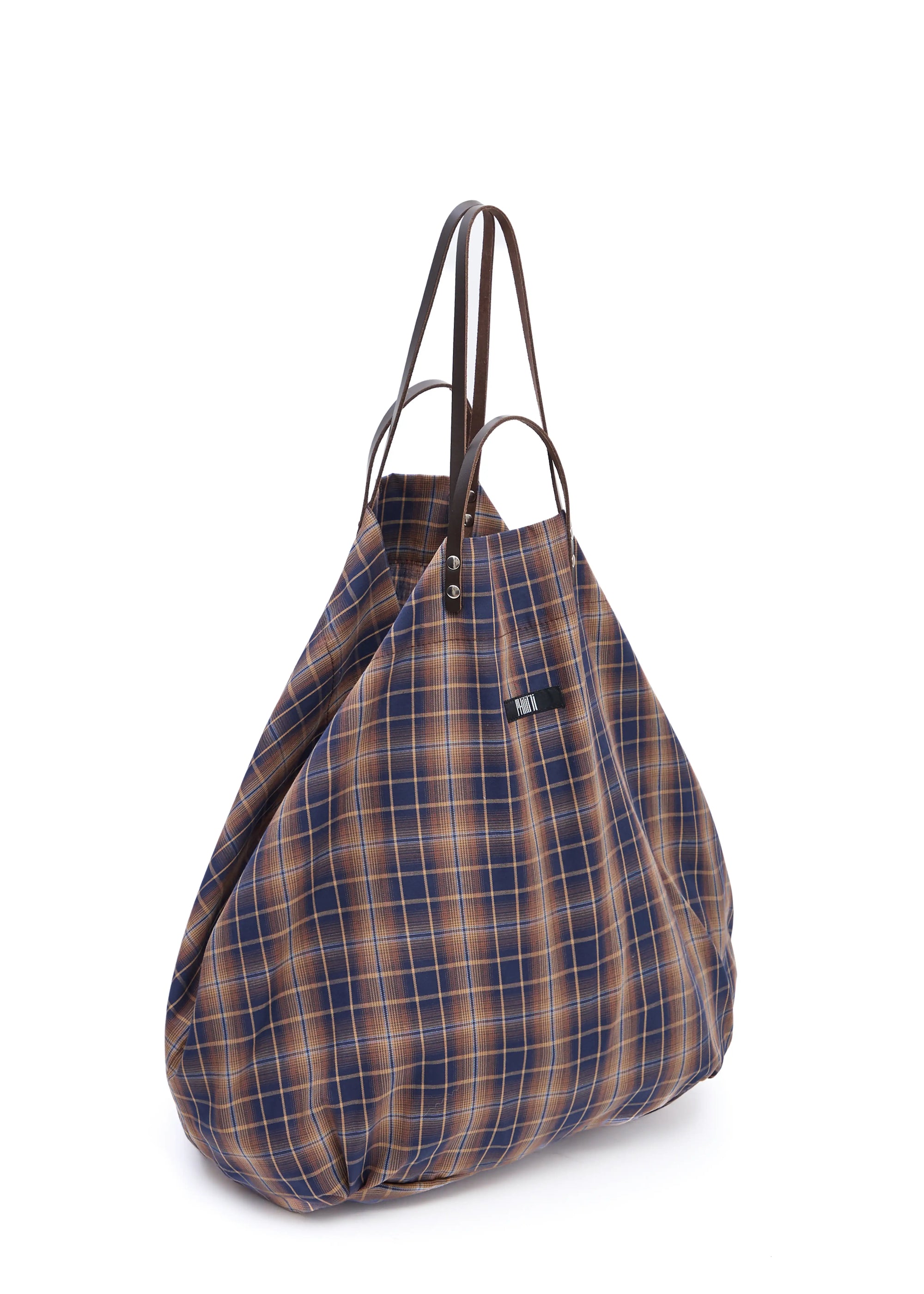 Side view of the Philini Shopper in checkered brown cotton, with short and long brown leather handles with silver attachments, and sewn logo detail. Stylish everyday shopper tote