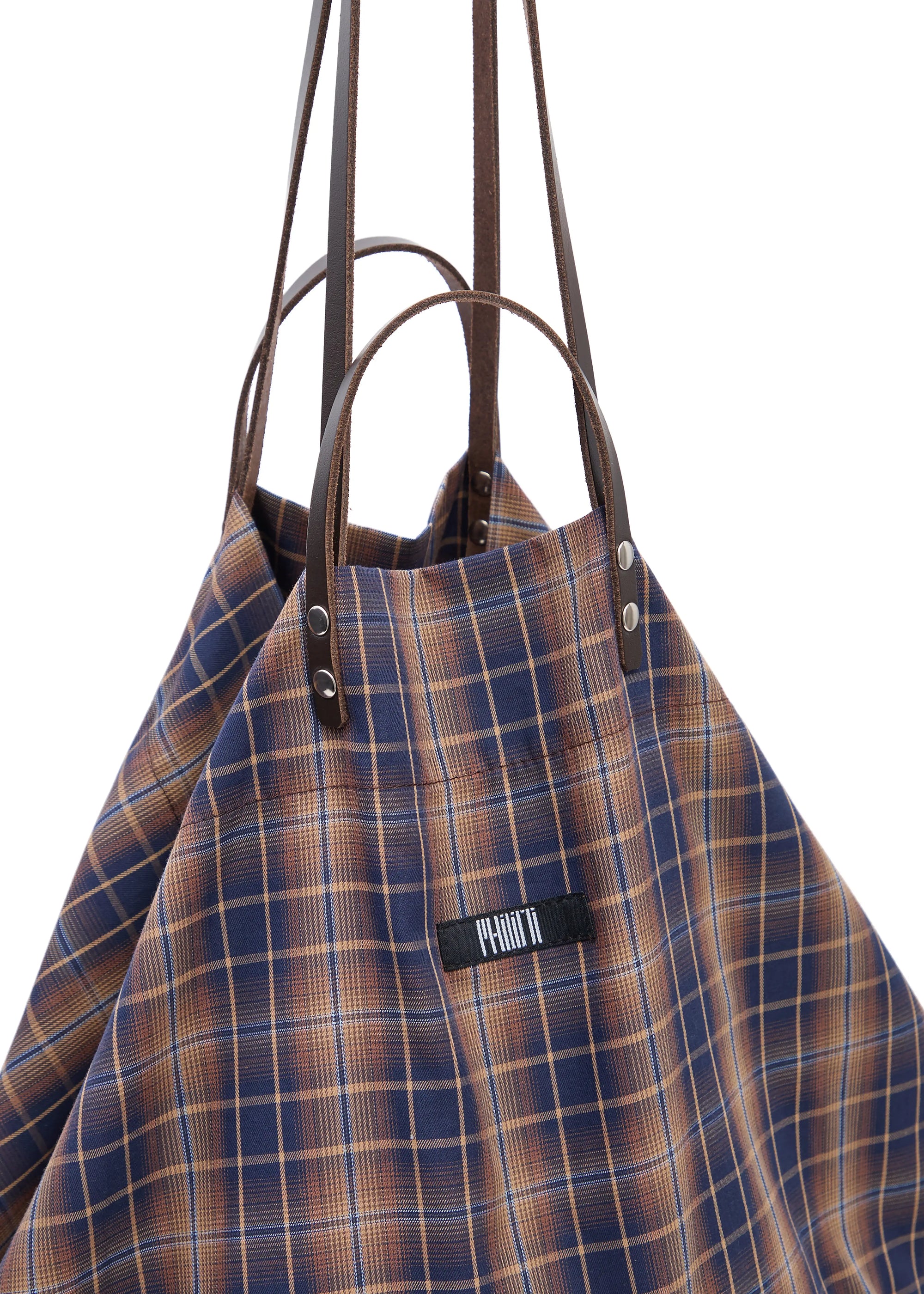 Close-up of the Philini Shopper in checkered brown fabric, highlighting two pairs of brown calf leather handles with silver hardware and secure top button closure. Durable handmade tote for modern everyday use.