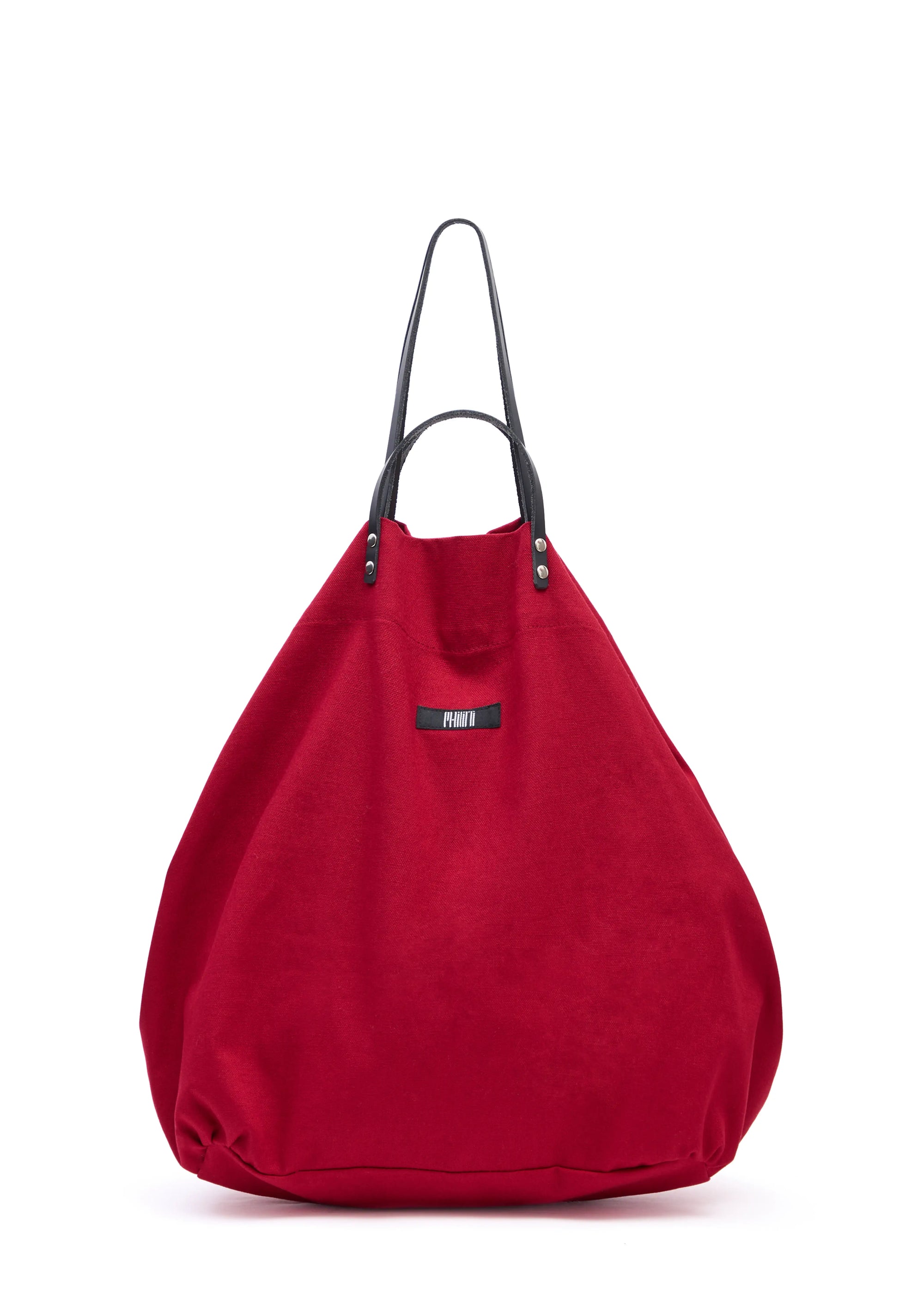 Front view of the Philini Shopper in bold red cotton, featuring short and long calf leather handles, top button closure, softly structured pear shape, and sewn fabric logo. Sustainable designer shopper bag