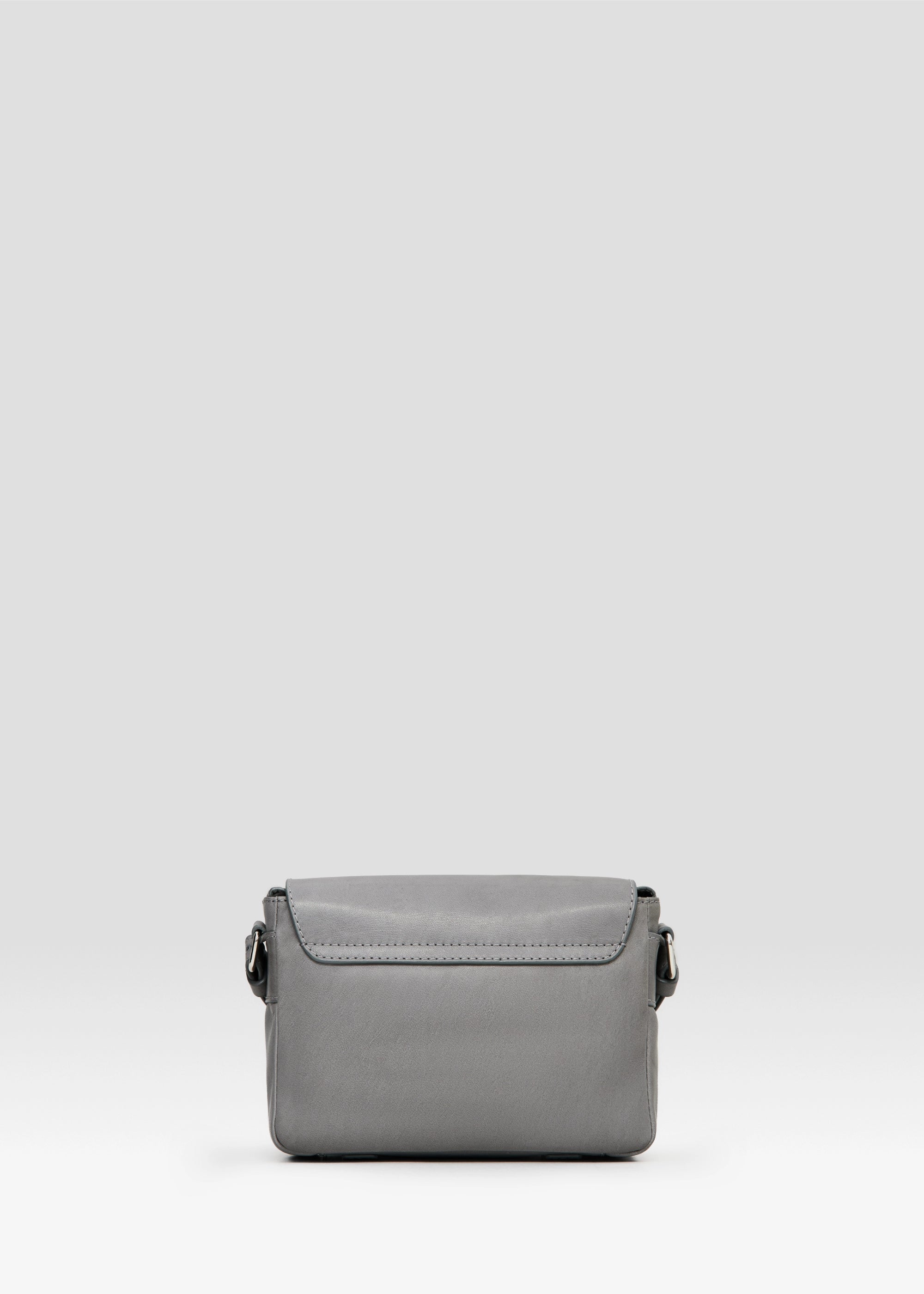 Back view of the grey Philini Whitney Mini Crossbody Bag in nappa leather, showing its rectangular shape, adjustable strap, and front flap attachment. A compact handcrafted bag for daily use and refined style