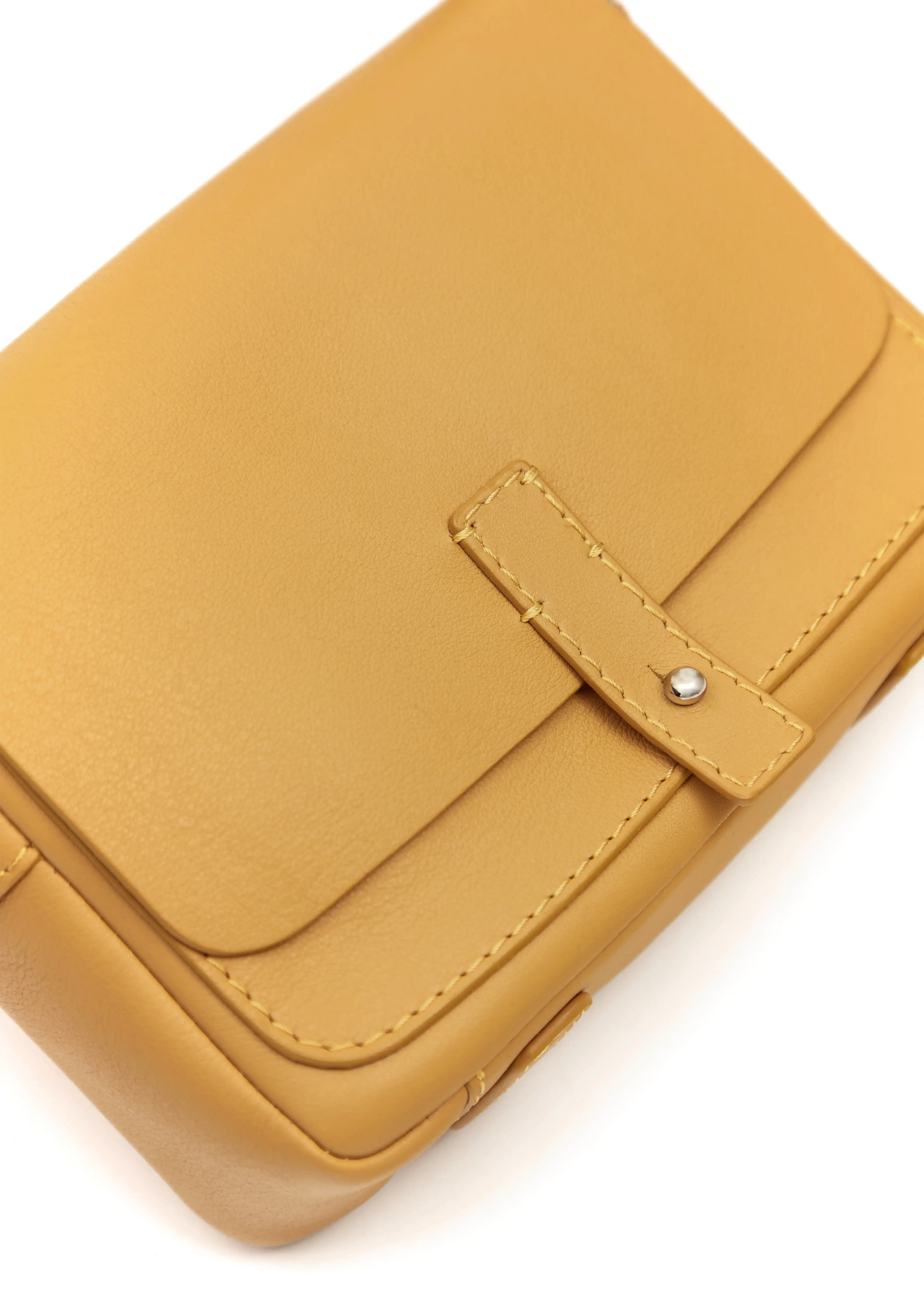 Close front view of the Philini Whitney Mini Crossbody Bag in yellow nappa leather, highlighting its natural leather texture, hand-stitched details, front flap with silver cufflink closure. The handcrafted mini designer handbag