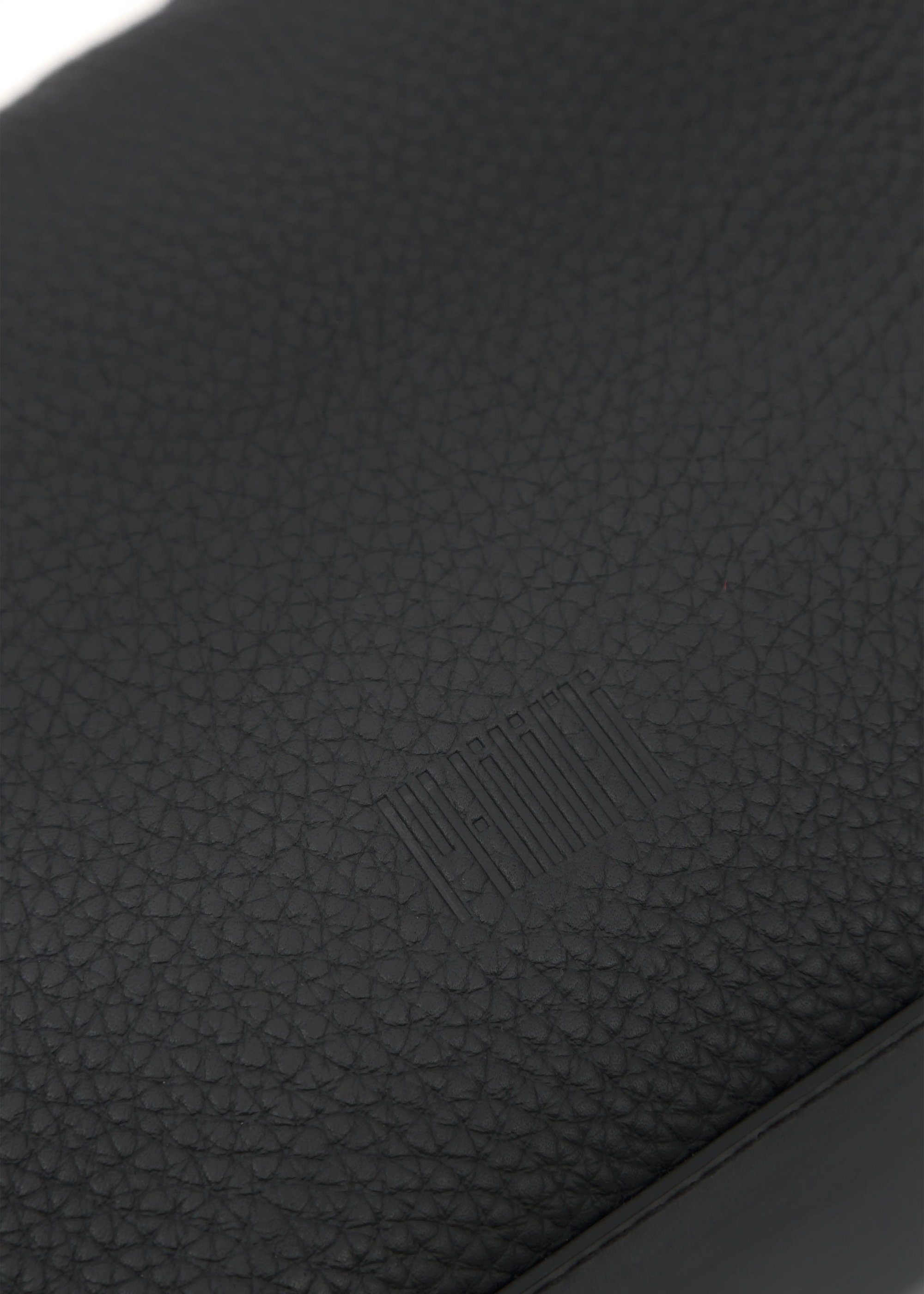Close-up of high-quality black buffalo leather with a stamped Philini logo