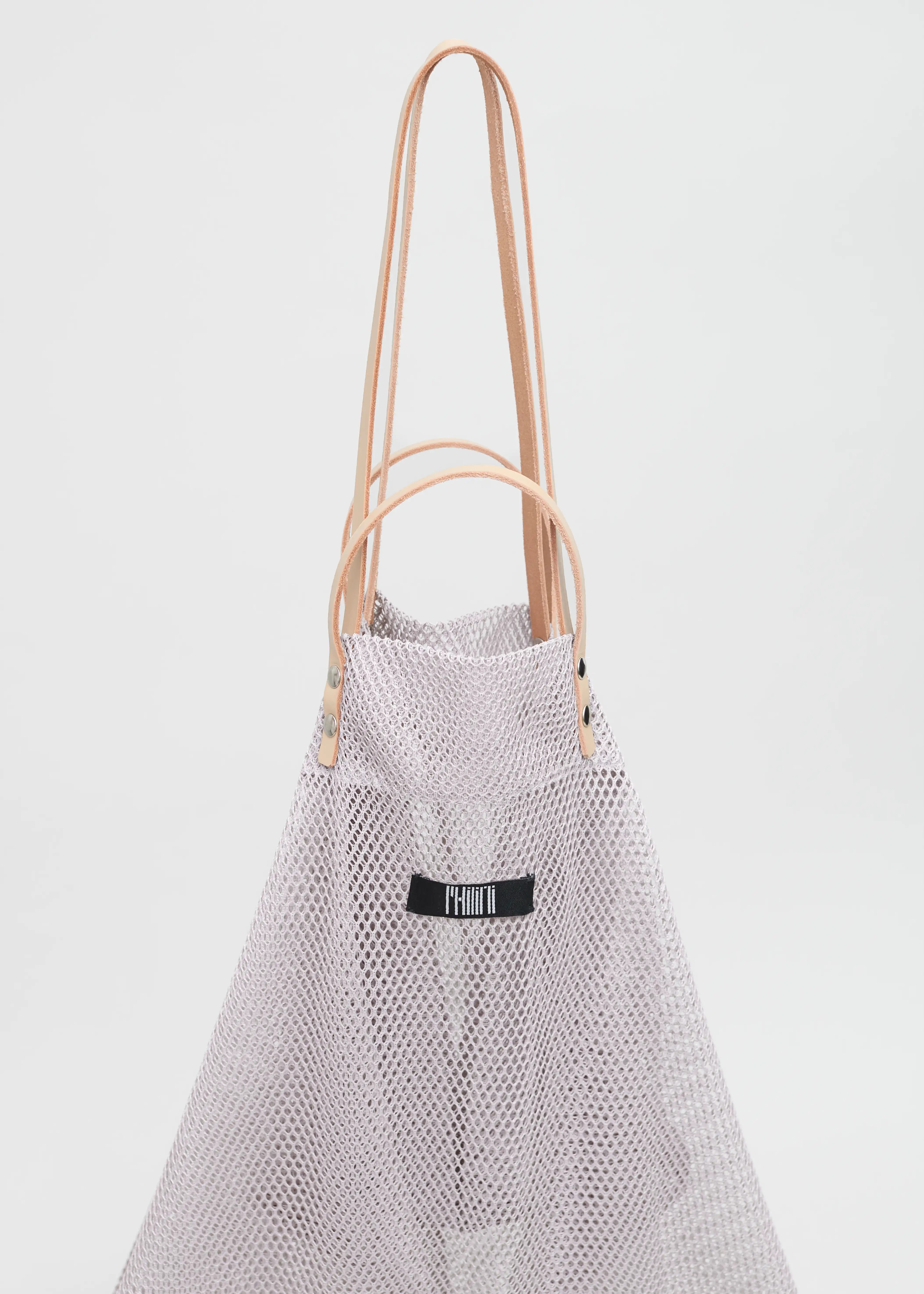 Close-up of the Philini Mesh Shopper, capturing the pear-shaped silhouette with double leather handles, silver hardware, and soft mesh fabric. Luxury handmade shopper