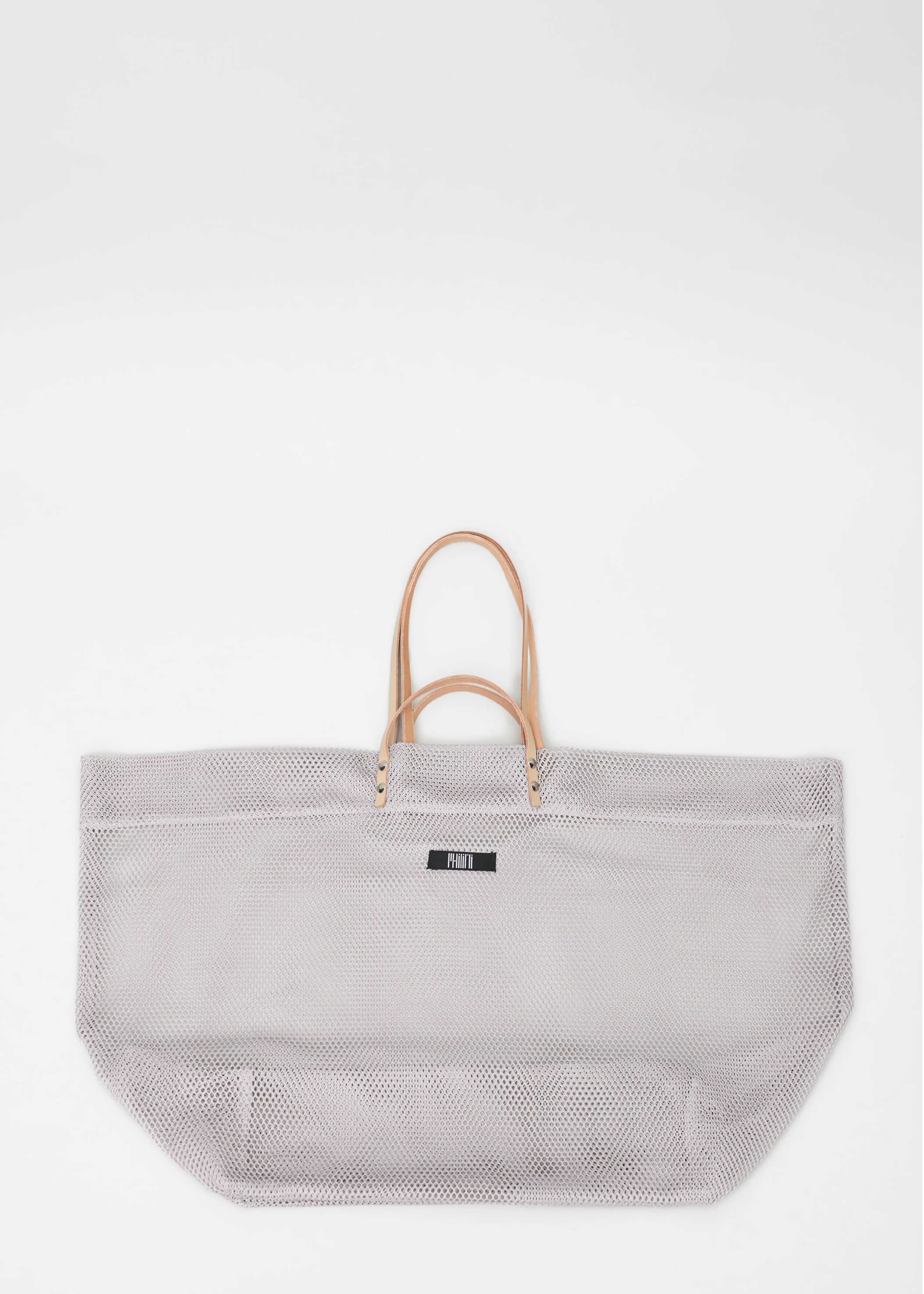 Top view of the Mesh Shopper, showcasing its full rectangular shape,  featuring short and long calf leather handles, and sewn Philini fabric logo. Handcrafted by the designer