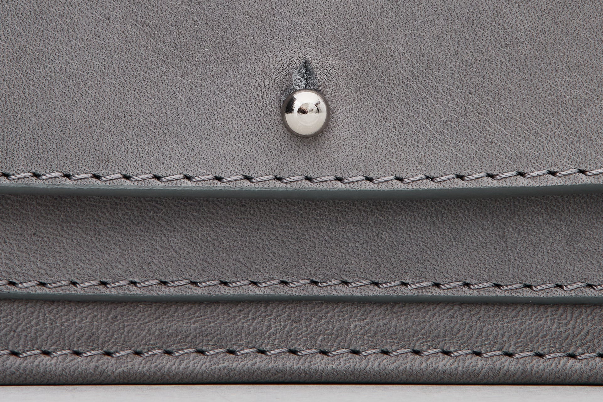 Close-up of a gray leather wallet with stitching details